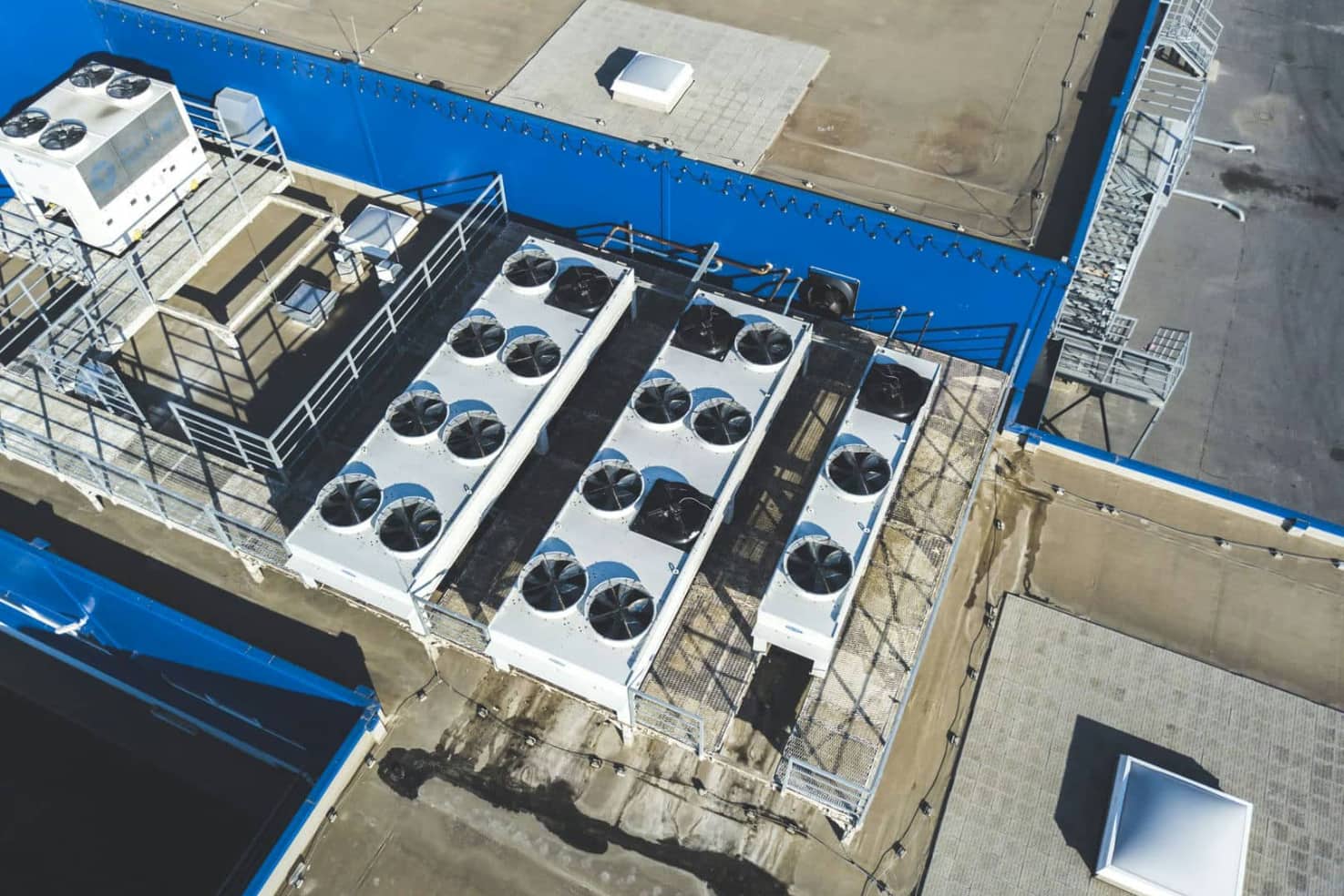 Aerial top view of industrial technical system machines on the rooftop of hangar building