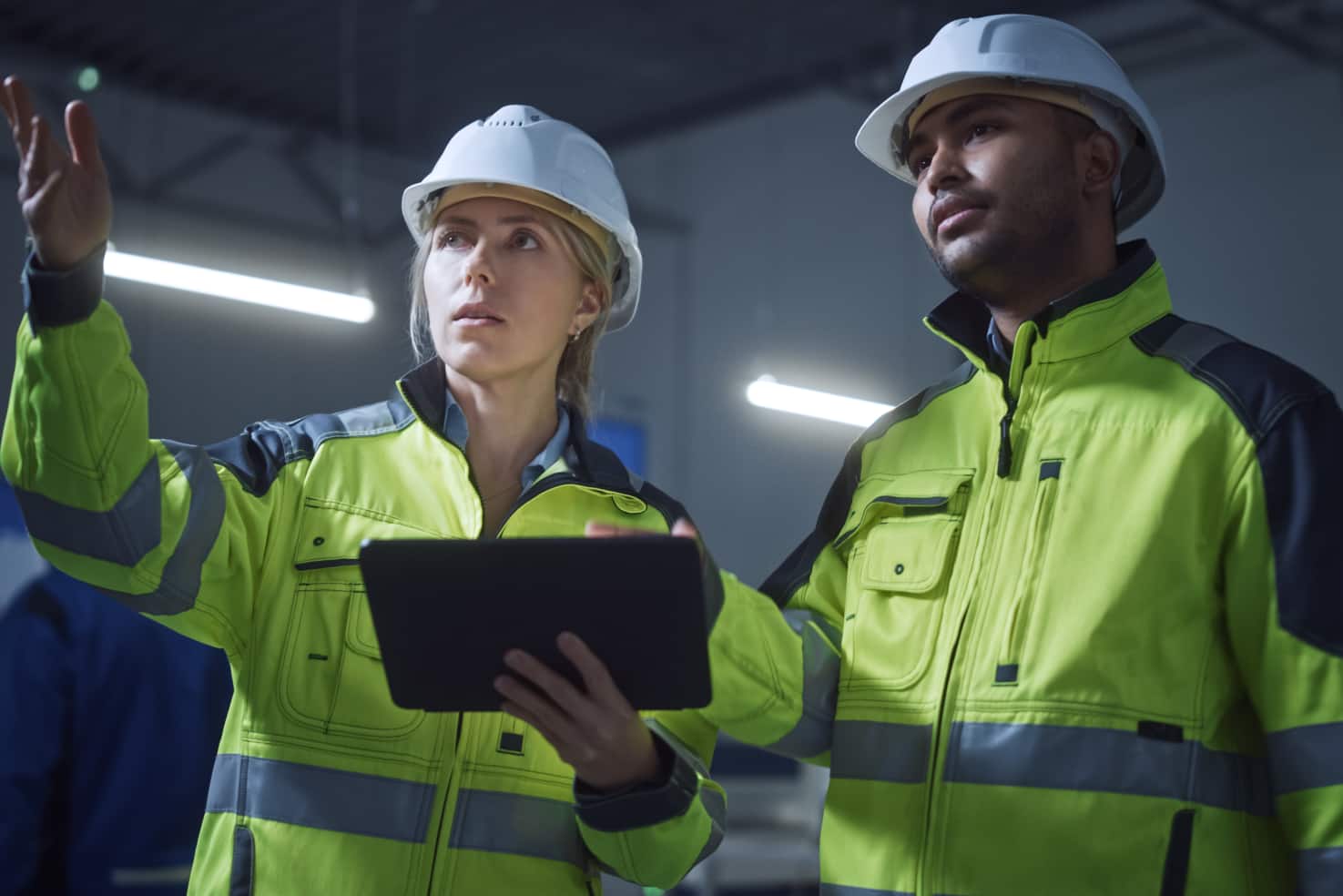Lady engineer Explaining task with tablet in hand to Male engineer in company