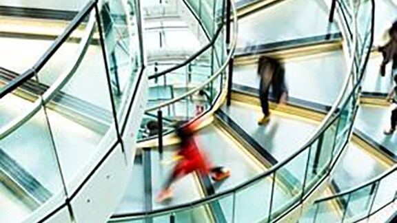 Motion blur picture of people getting down the circular stairs 