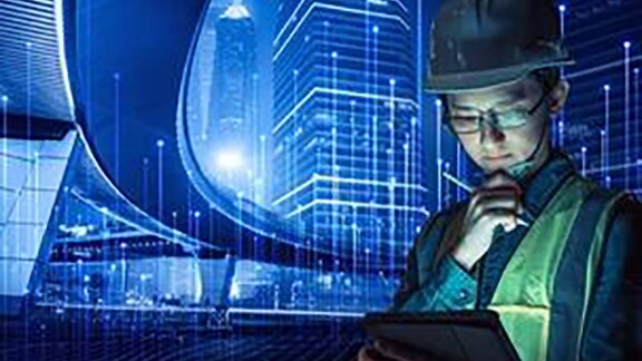 An employee looking at his tab standing near the glass window of the corporate office overlaid with graphics of transmission of nodes 