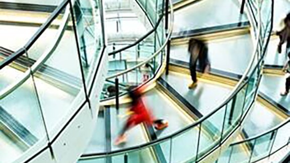 Motion blur picture of people getting down the circular stairs