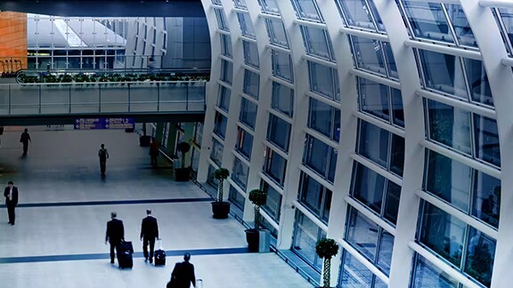 Interior motion view of people walking through a modern airport terminal
