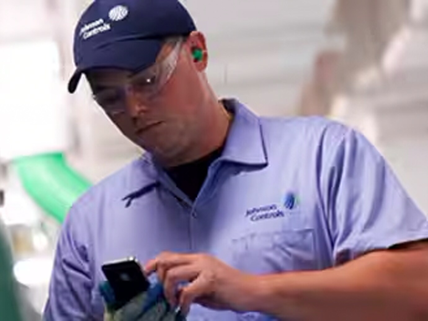 Close-up of Johnson Control employee checking his mobile