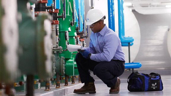 Closeup of a technician taking the reading of the installed chillers