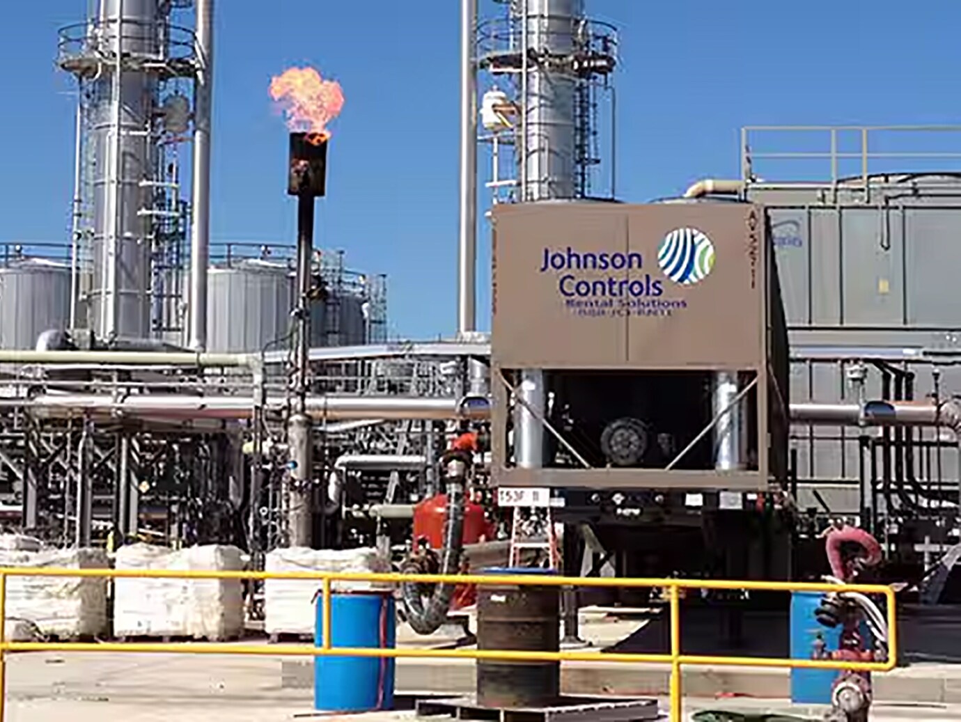 Displays an industrial facility with Large piece of equipment displaying Johnson Control logo