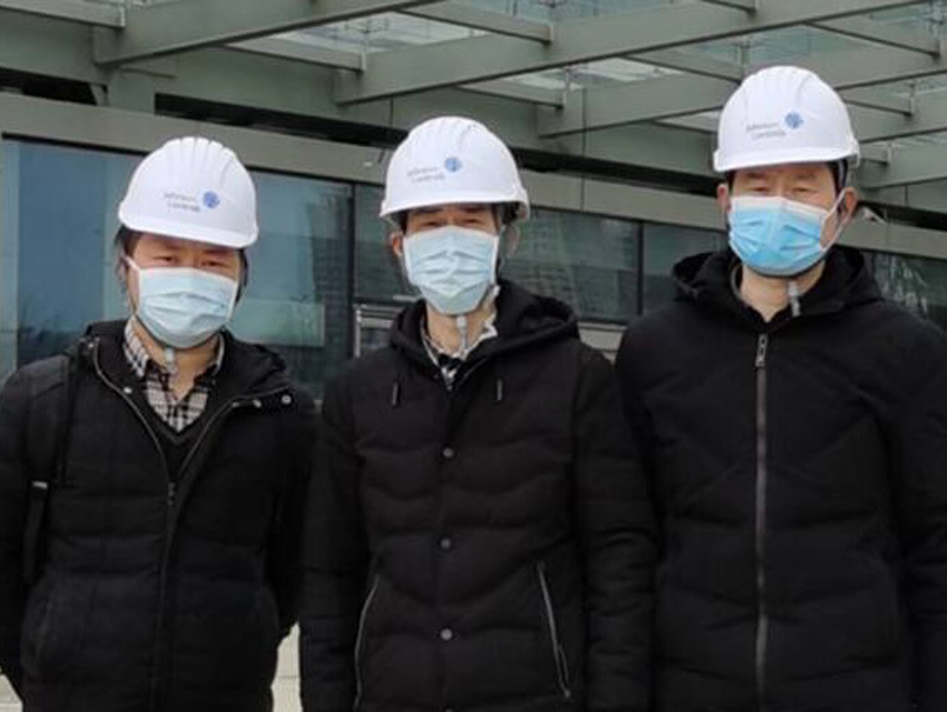Three Johnson Controls chinese employees standing infront of office