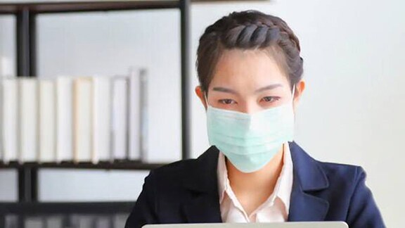 Professionals wearing masks and working in an office