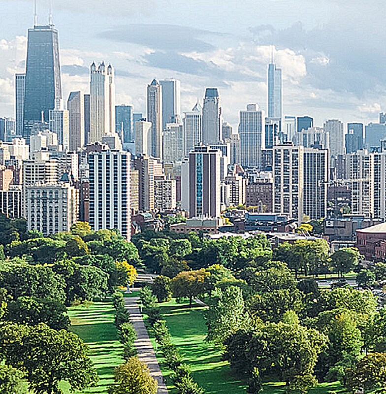 View of a Cityscape with a lush green park in the foreground in daylight