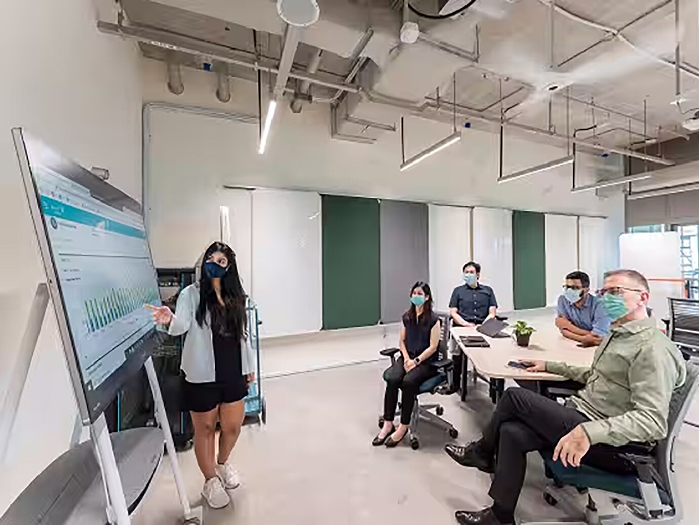 Woman employee presenting infront of group of employees