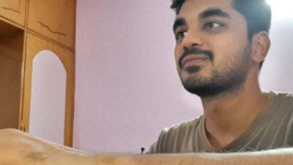 A man works on a laptop at his desk,