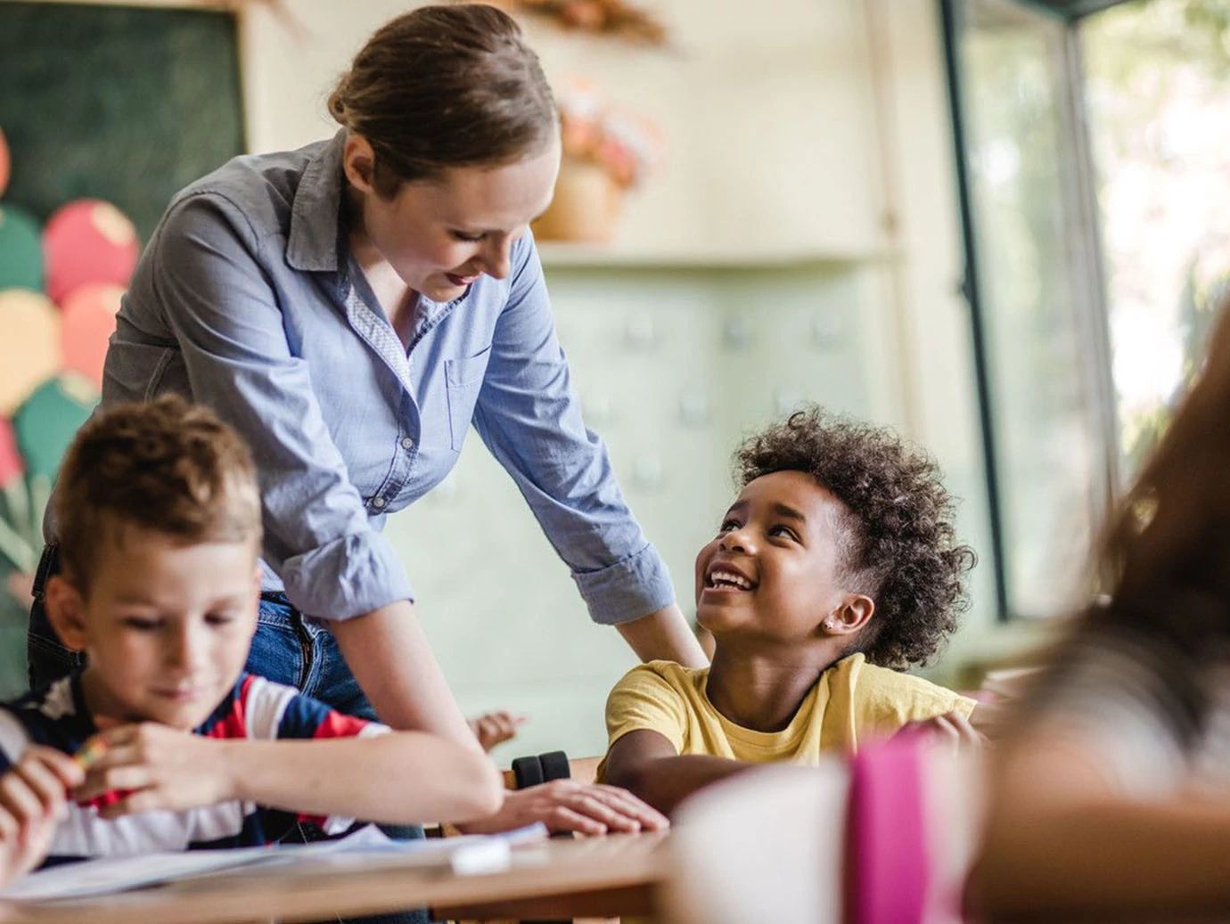 An elementary school teacher guiding her students in a classroom