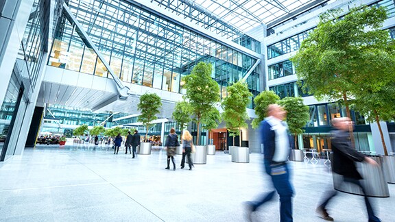 People walking along an atrium of an office building