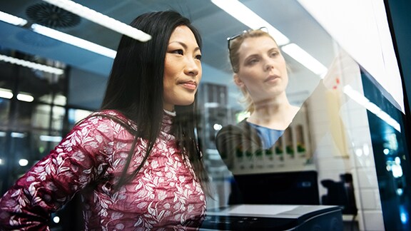 Two women looking through a window