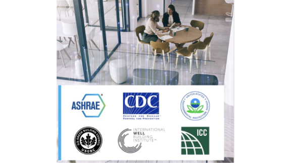 Interior of a cafe, where two women are chatting at a table, with a collage of logos of various American associations