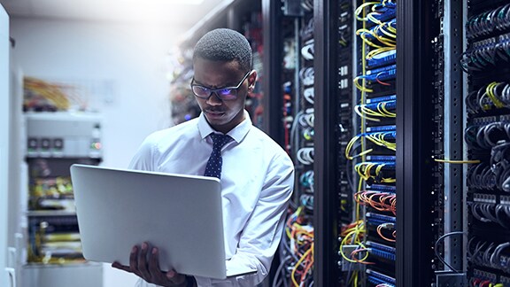 Man holding a laptop in datacenter