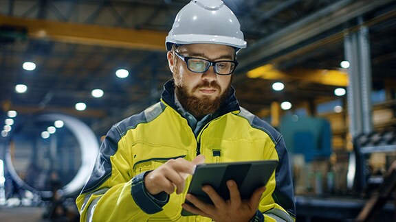 A maintenance engineer scrolling on a tablet
