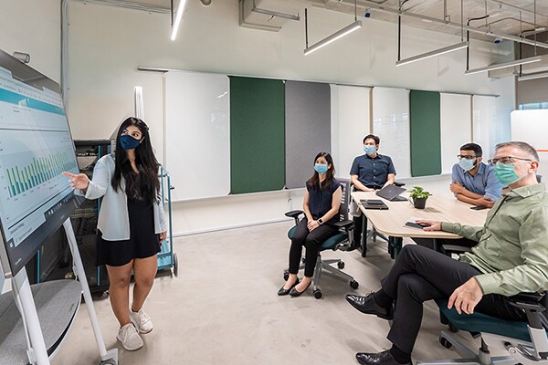 A women employee explaining the team about the graphs in a conference room