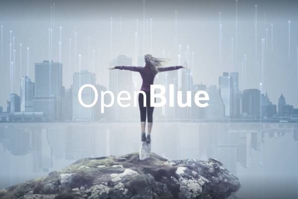Woman standing at the edge of a cliff with a lake and the cityscape in the background, overlaid with "OpenBlue"