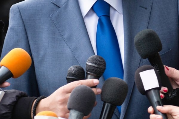 An executive getting interviewed with mics infront